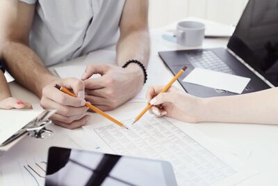 Eventplanung - 3 Leute sitzen an einem Tisch und Planen ein Firmenevent