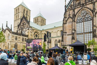 Menschen stehen vor einer LED Wand am Dom zu Münster